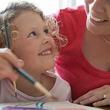 child painting with adult woman